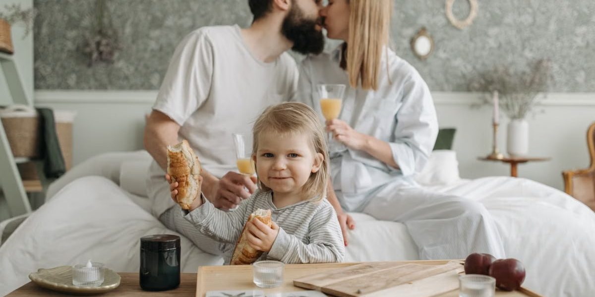 Family enjoying breakfast in bed, expressing love and togetherness.