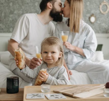 Family enjoying breakfast in bed, expressing love and togetherness.