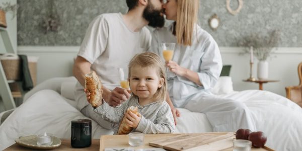 Family enjoying breakfast in bed, expressing love and togetherness.