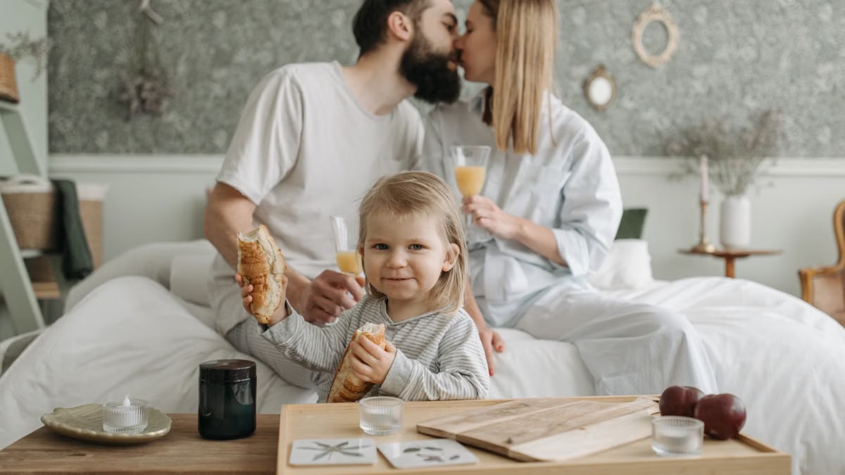 Family enjoying breakfast in bed, expressing love and togetherness.